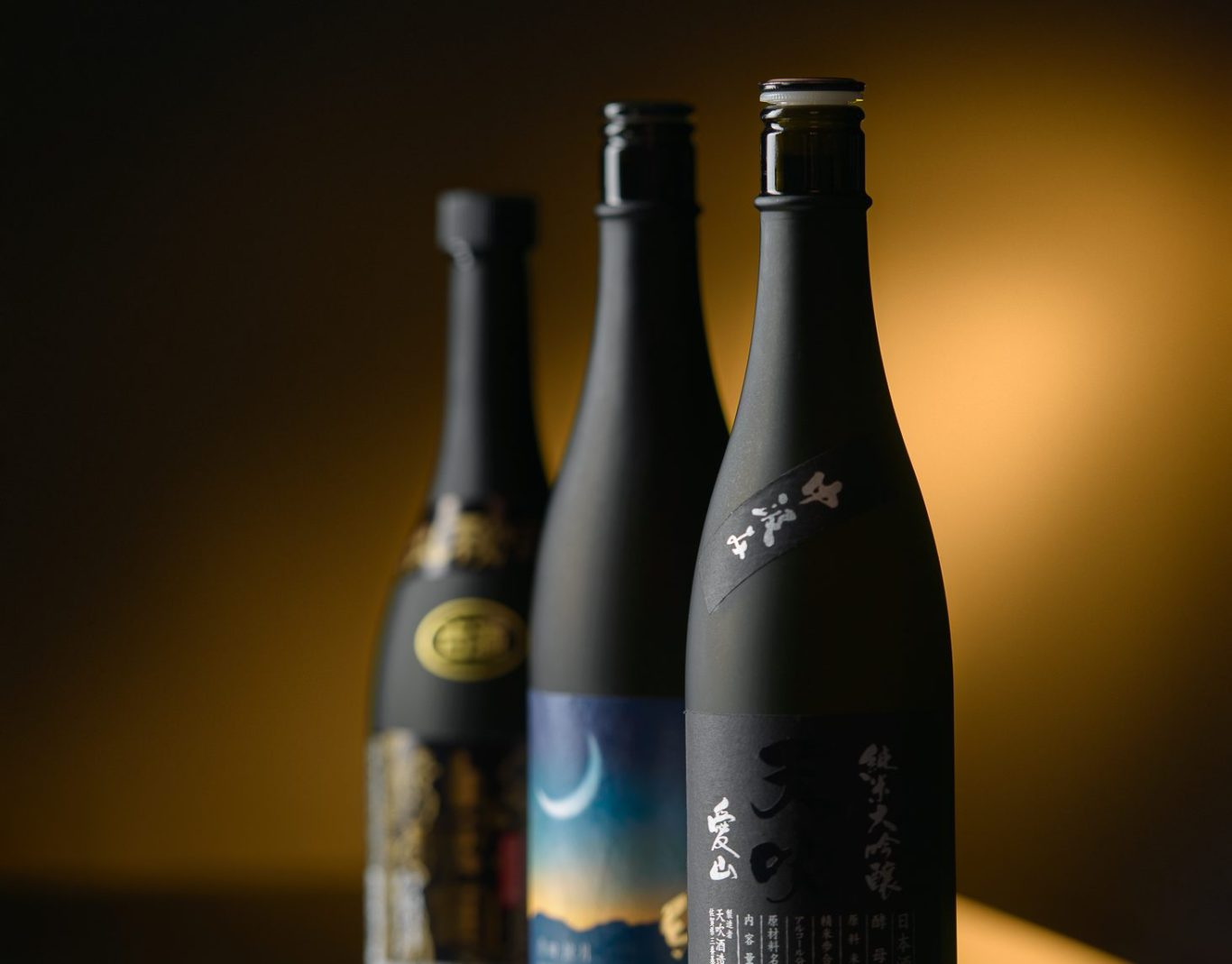3 belles bouteilles noires de sakés alignées