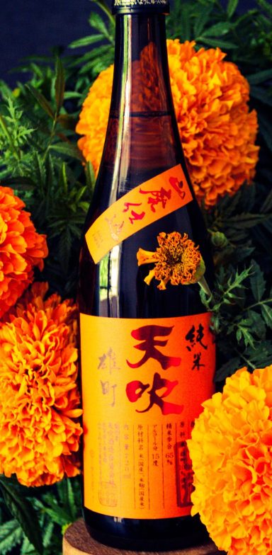 Bouteille de la maison Amabuki dissimulée dans un bouquet de fleurs