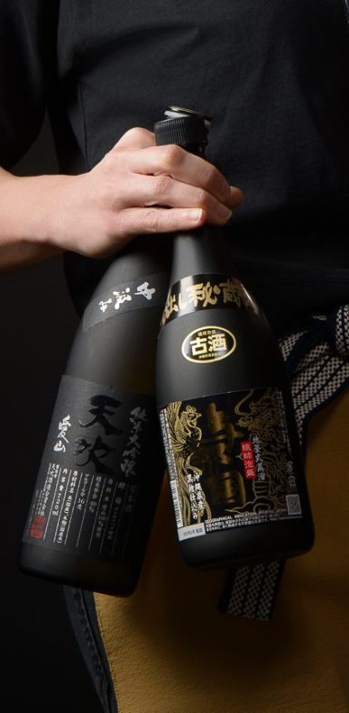 Vue en gros plan de 2 magnifiques bouteilles noires : un saké et un Awamori